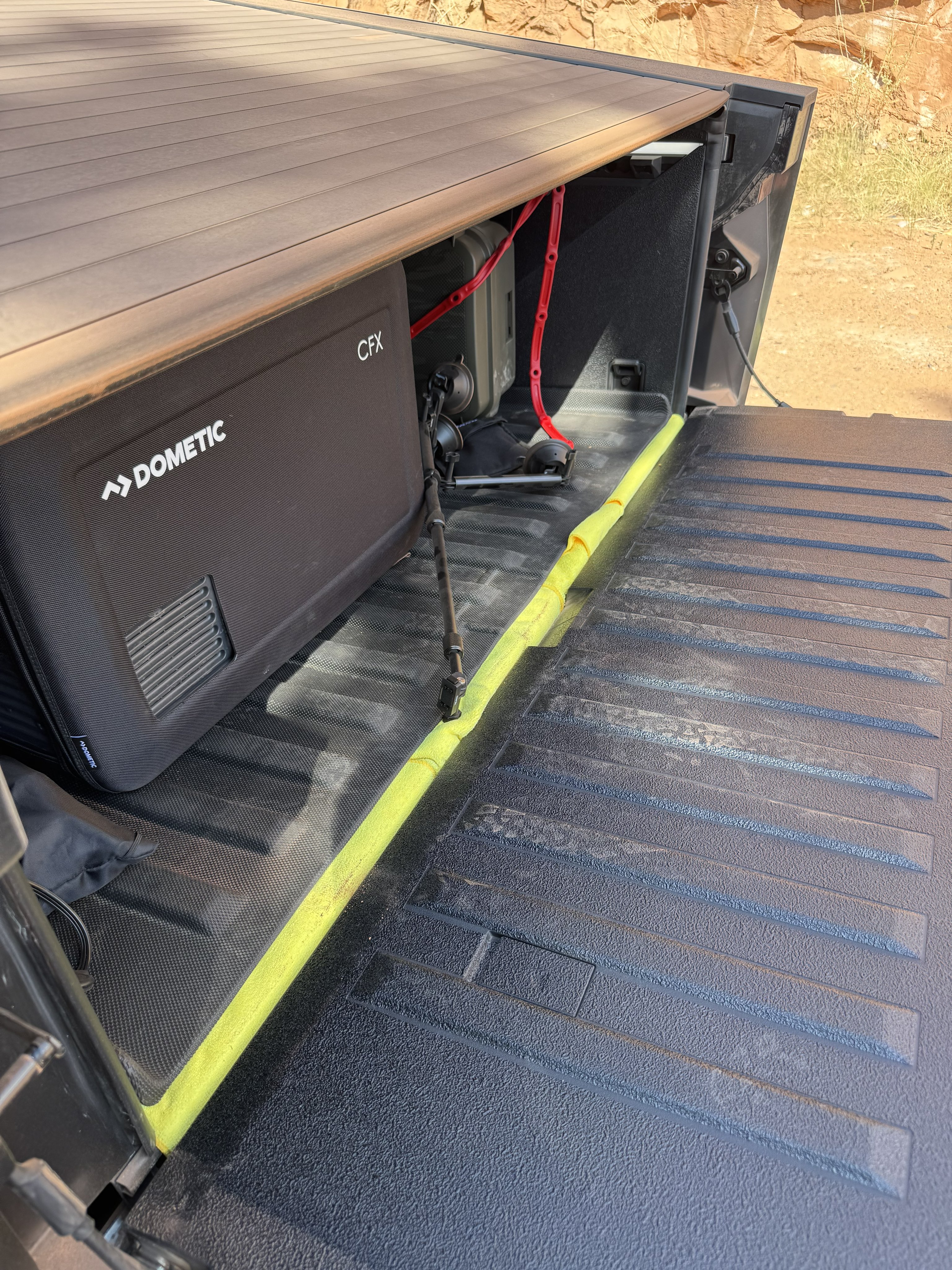 Microfiber towels tucked under bed mat edge to seal floor gaps in Cybertruck vault